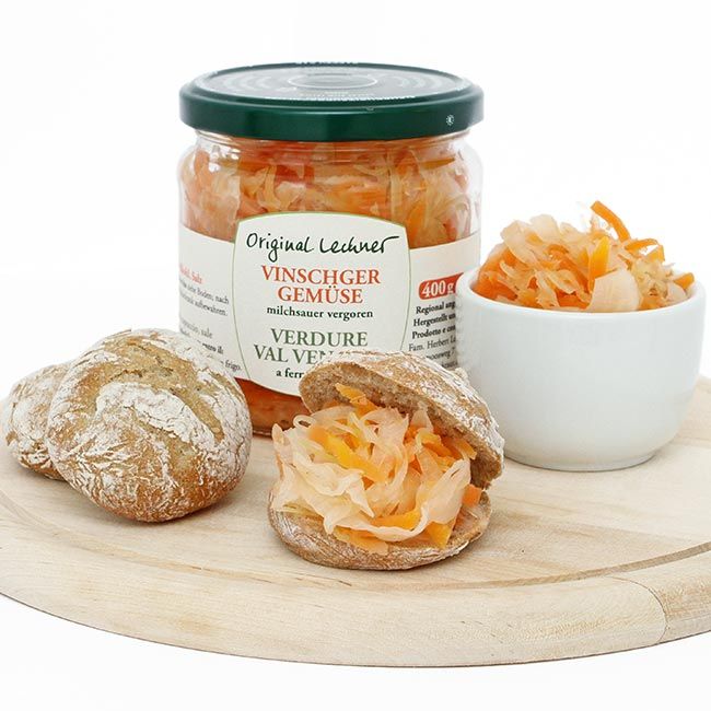 Vinschger Gemüse Gelb“ von Original Lechner – milchsauer vergoren und servierfertig im knusprigen Vinschger Brötchen. Authentische Südtiroler Brotzeit mit fermentiertem Karotten-Kraut-Sellerie-Mix.
