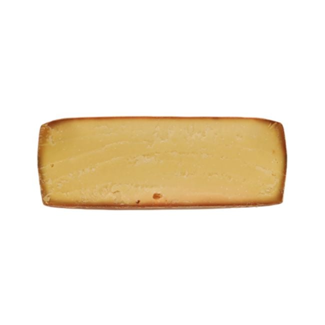 Servieren Sie den "Kristall" Bergkäse in appetitlichen Stücken, neben einer Auswahl an Nüssen und getrockneten Früchten, präsentiert auf einem eleganten Käsebrett für eine anspruchsvolle Käseverkostung.