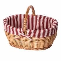 Rustikaler Picknickkorb aus gesottener Vollweide mit einem nostalgischen rot-weiß gestreiftem Stoffüberschlag.