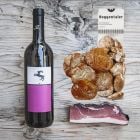 Geschenkpaket gefüllt mit typischen Südtiroler Brotzeit-Basics: Rotwein, Brettlspeck und Mini-Schüttelbrot.